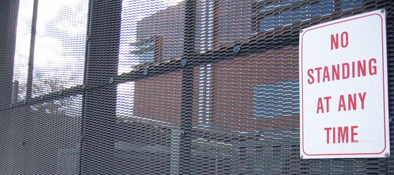 A metal mesh fence in front of a building.
